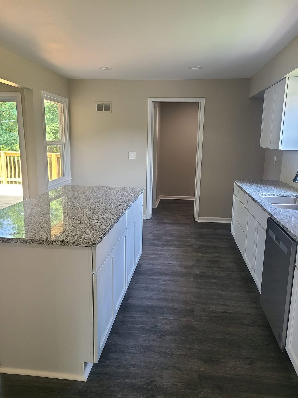 Kitchen with granite island and white shaker cabinets